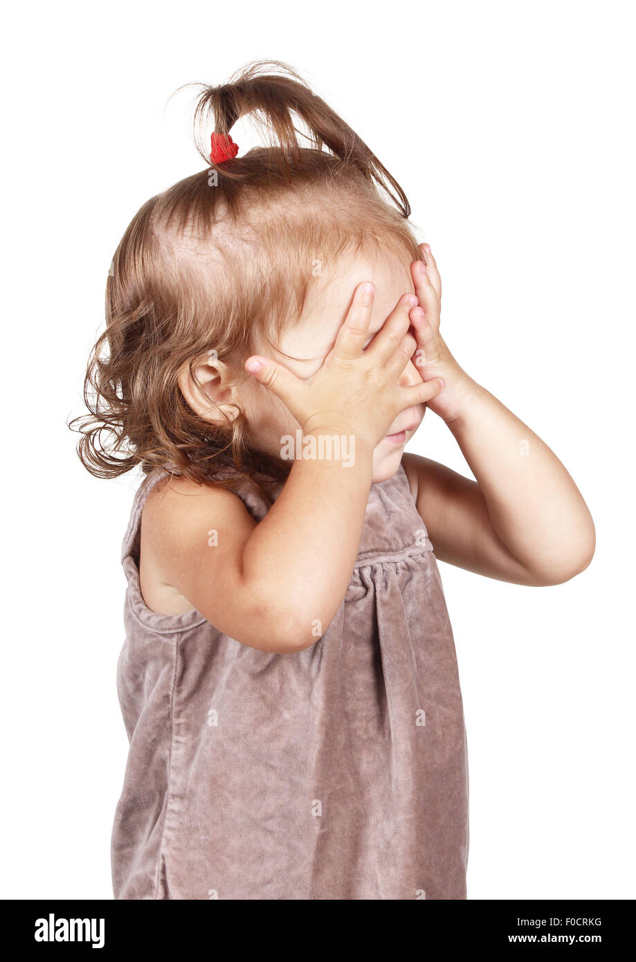Bambina nascondere la faccia sotto le mani, isolato su bianco Foto Stock