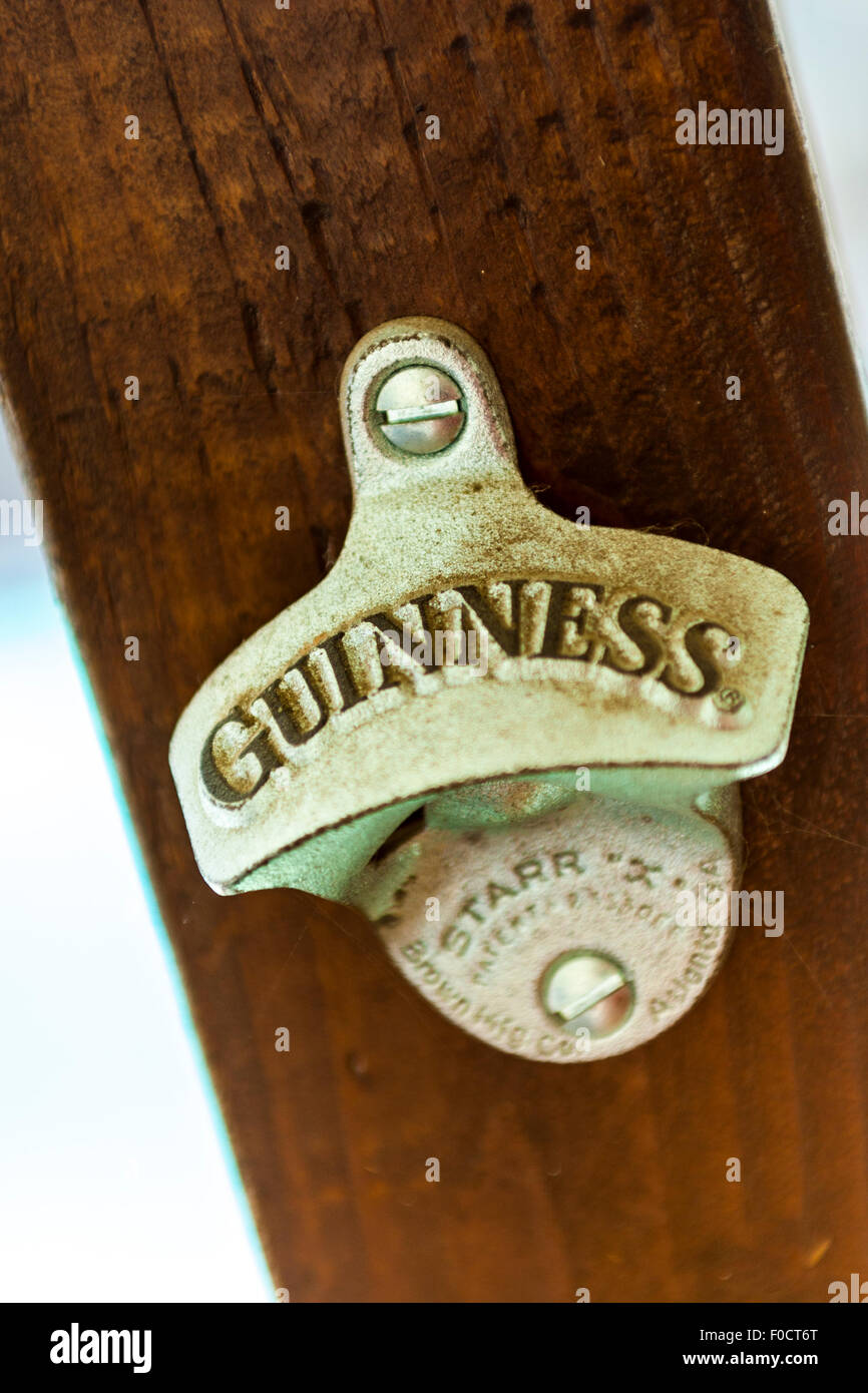 Un Guinness apribottiglie su un palo di legno Foto Stock