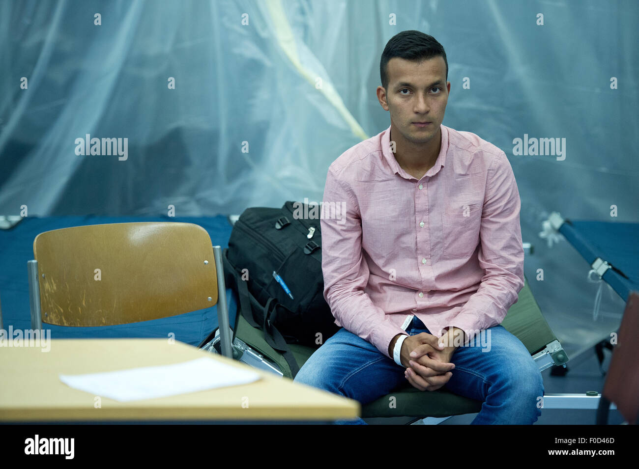 16-anni rifugiato Ali dall Afghanistan si siede in una improvvisata sala di interrogazione e attende il suo trasporto ad un alloggio per adolescenti rifugiati nella stazione della polizia federale presso la stazione centrale di Francoforte sul Meno, Germania, 05 agosto 2015. Foto: BORIS ROESSLER/dpa Foto Stock
