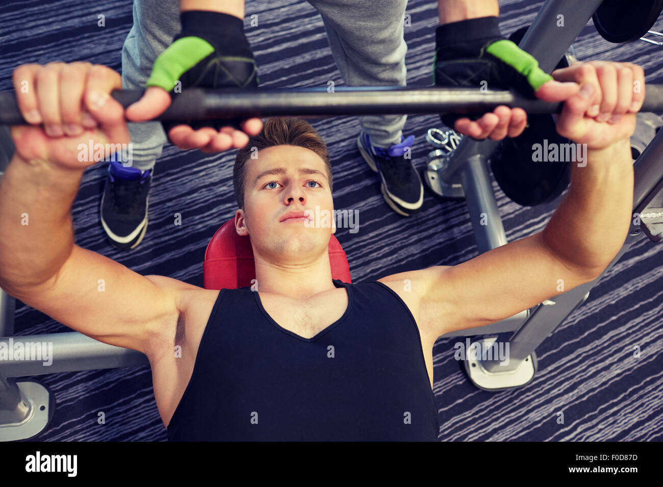 Gli uomini facendo barbell pressa da banco in palestra Foto Stock