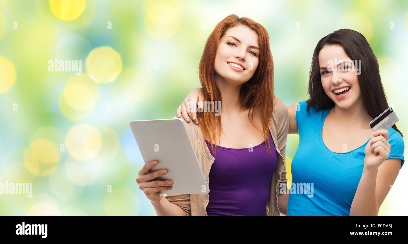 Due ragazze sorridenti con tablet pc e carta di credito Foto Stock