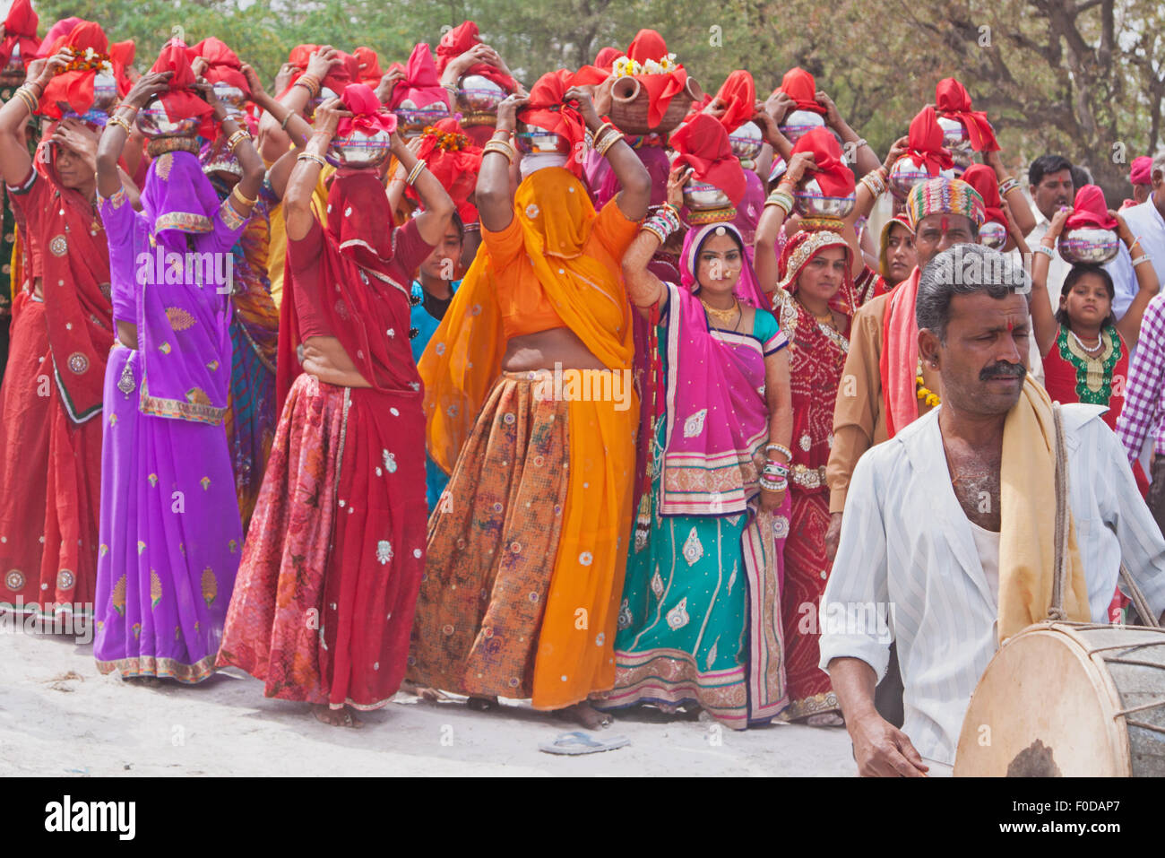 Il batterista donne protagoniste nel tipicamente abito colorato all'inizio di una processione durante il festival indù di Gangaur in Rajasthan Foto Stock