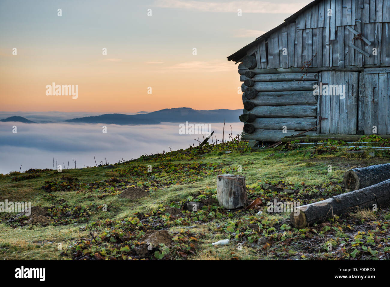 Vecchia casa di fronte la splendida natura con le nuvole oceano, campo di erba e montagne Foto Stock