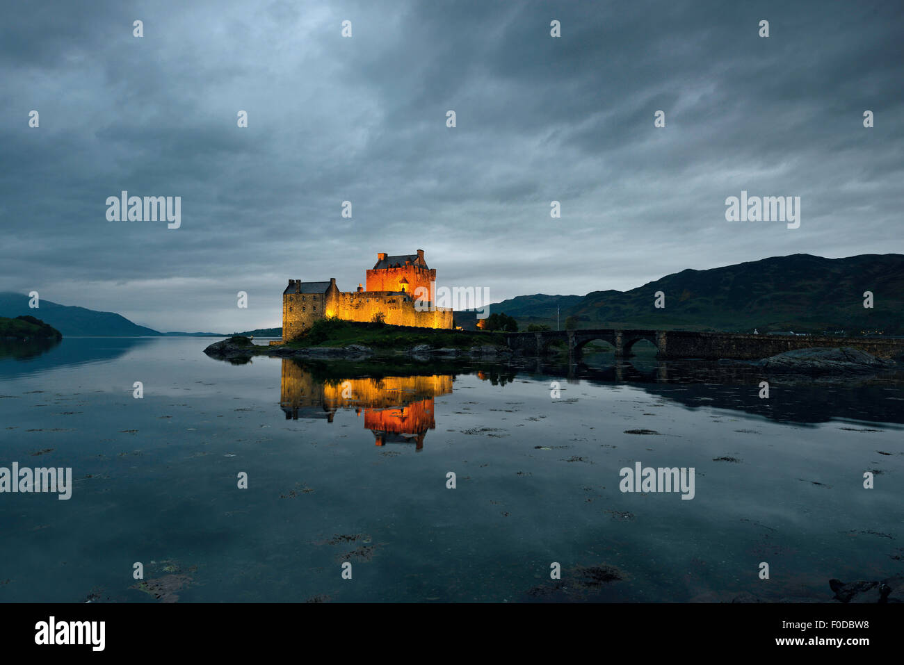 Eilean Donan Castle, sede ancestrale del clan scozzesi di Macrae, riflessione in serata a Loch Duich, Dornie Foto Stock