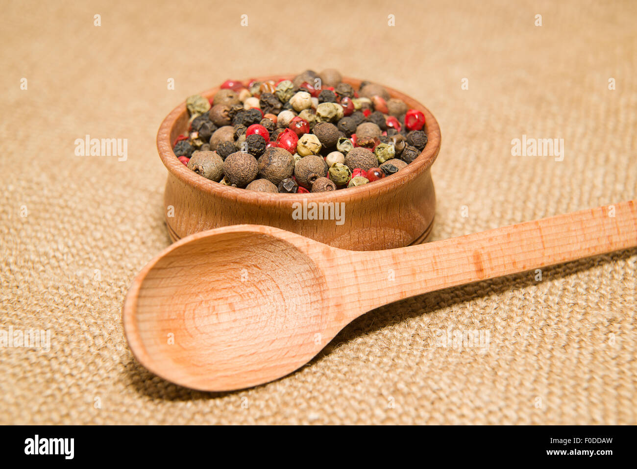 Una miscela di grani di pepe e il cucchiaio sul panno vecchio Foto Stock