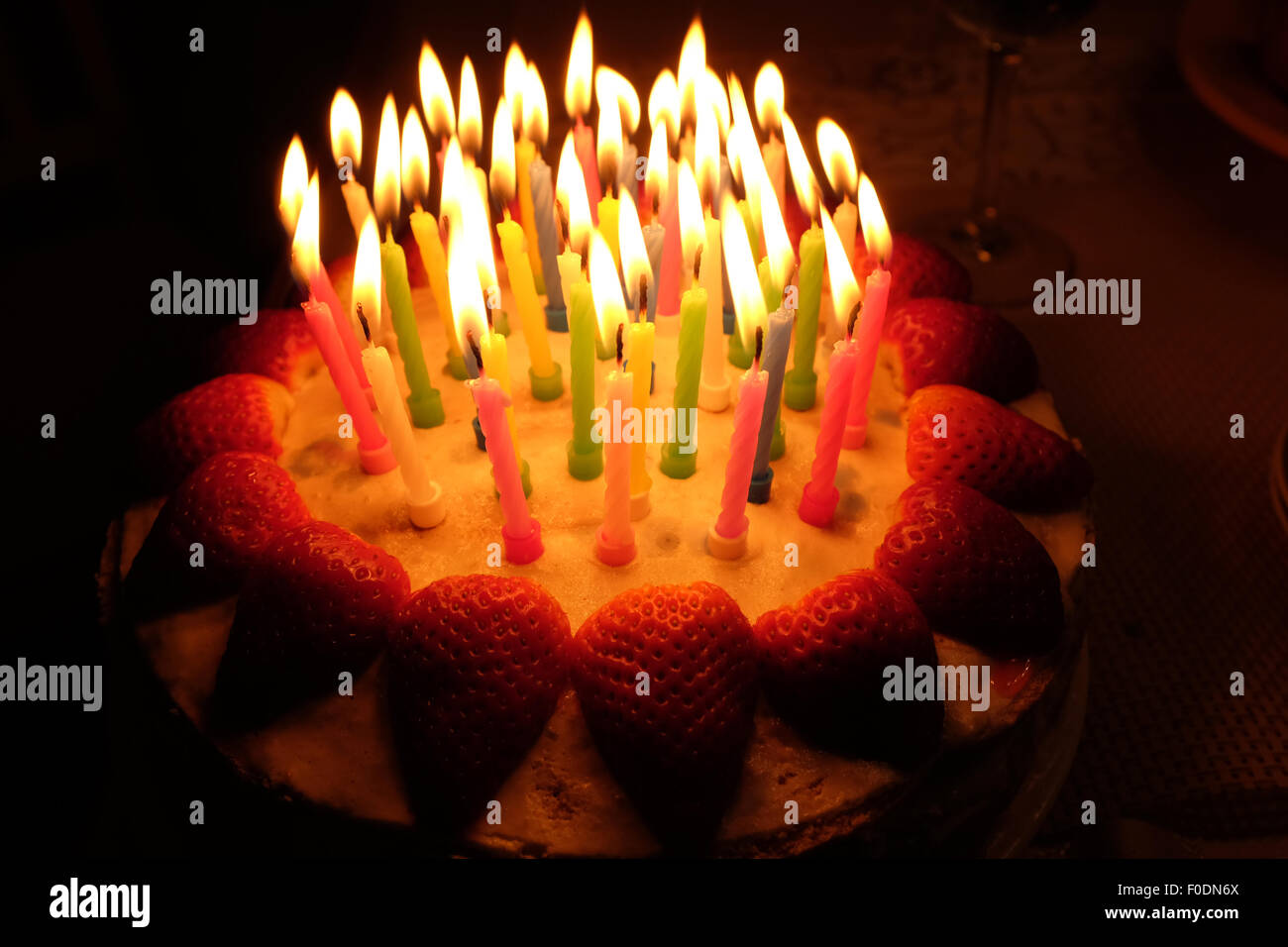 Un compleanno la torta di fragole con candele accese Foto Stock