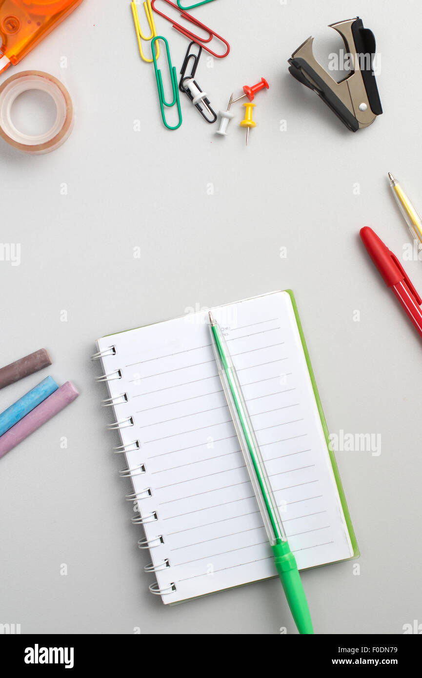 Scuola materiali come pastelli, notebook, clip, cucitrice, prencils sul tavolo Foto Stock