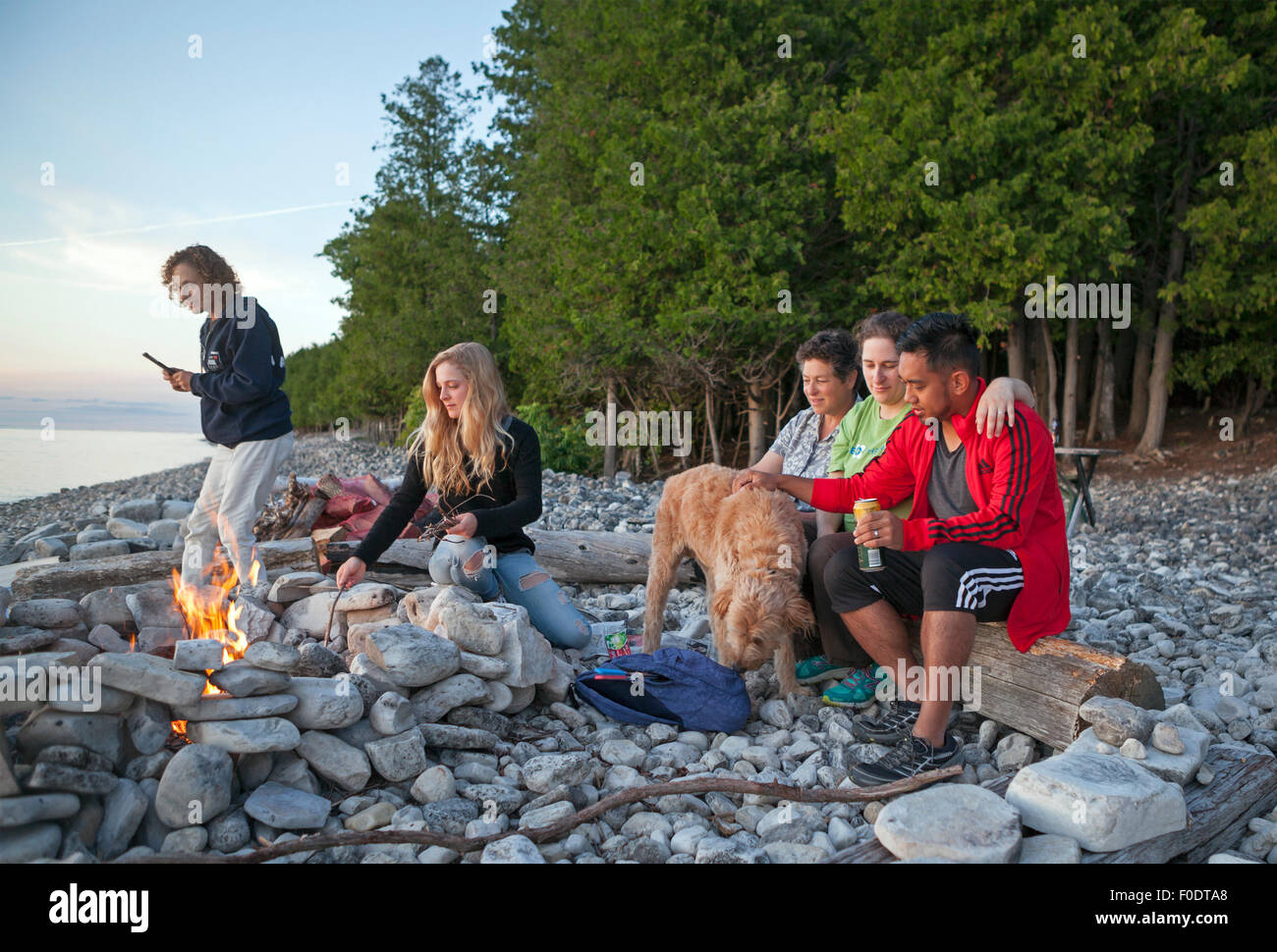 I membri della famiglia si riuniscono per un falò a Washington Island, Door County, Wisconsin, Stati Uniti. Foto Stock