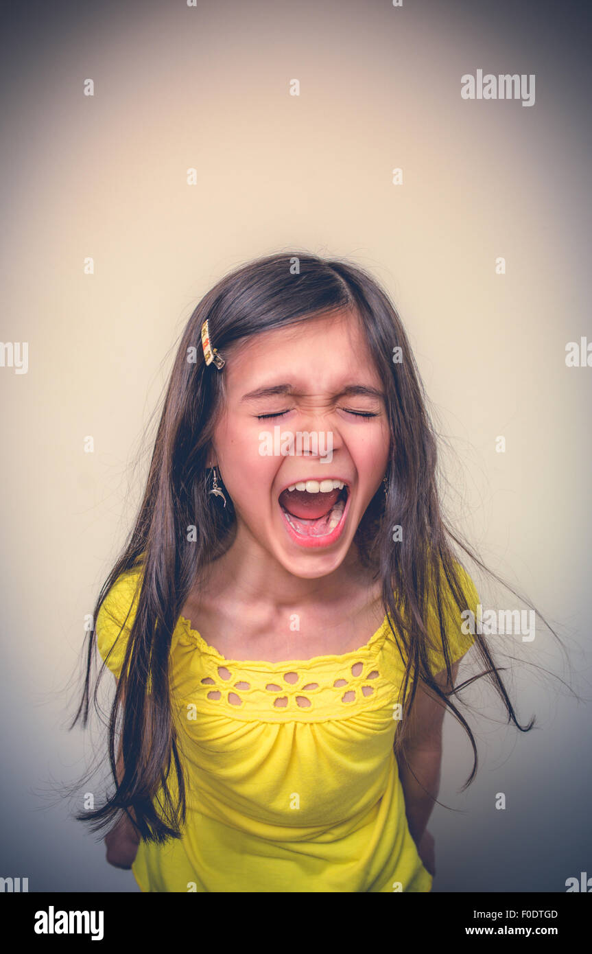 Bambina che urla in cima ai suoi polmoni fino a quando non è rossa in faccia. Foto Stock
