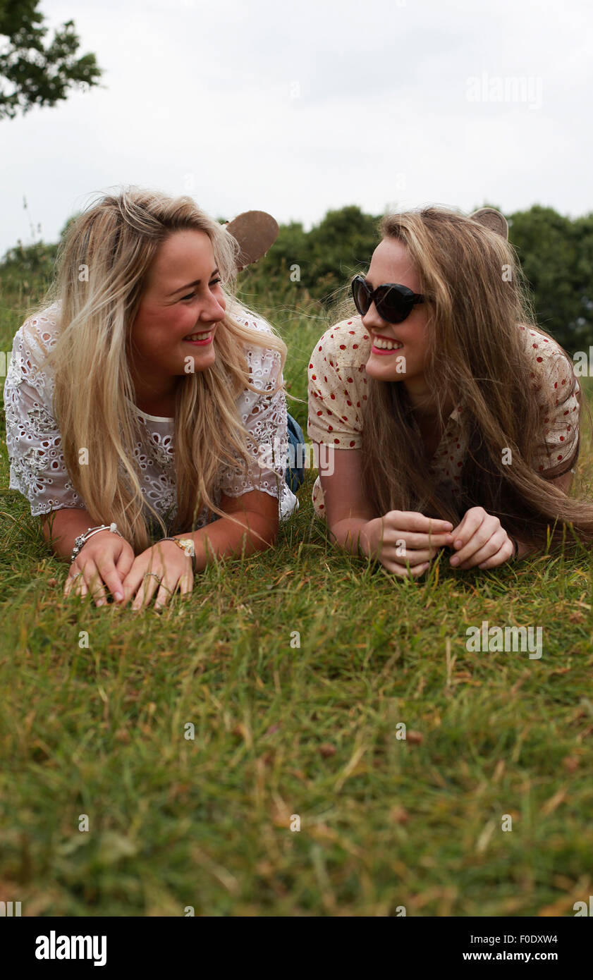 Due ragazze adolescenti che giace in erba ridere Foto Stock