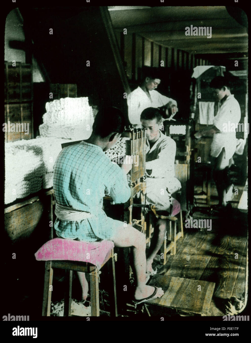 Questa immagine raffigura una persona che esamina il filo di seta, mostrando i dettagli e la maestria artigianale richiesti nella produzione della seta. Il processo evidenzia la natura complessa della produzione tessile e il suo significato culturale. Foto Stock