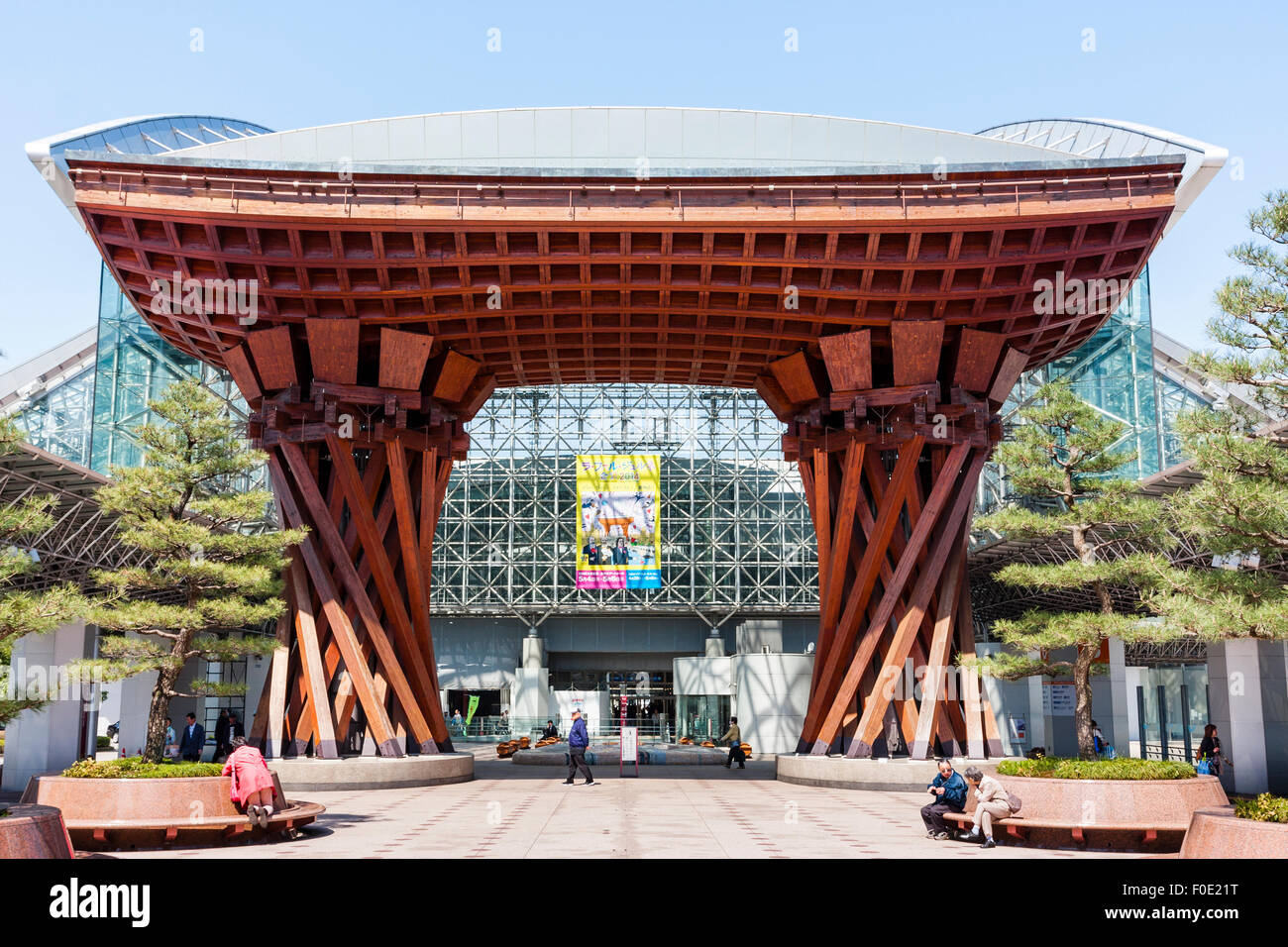 Giappone, Stazione di Kanazawa. La orange Tsuzumi-mon, tamburo gate conformata al di fuori dell'atrio, Motenashi (Benvenuti) vetro incorniciato Dome. Blue sky. Foto Stock