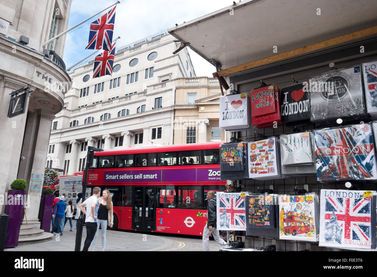 London street scene con stalla, Union Jack e bus rosso, Strand, Londra UK Foto Stock
