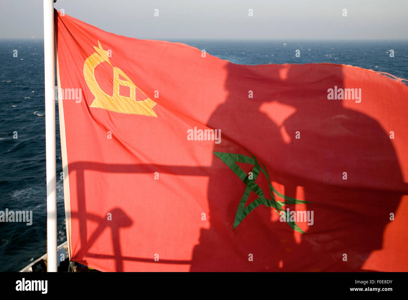 Paio di baciare ogni altra con ombra in Marocco di bandiera tessitura con il Mar Mediterraneo in background Foto Stock