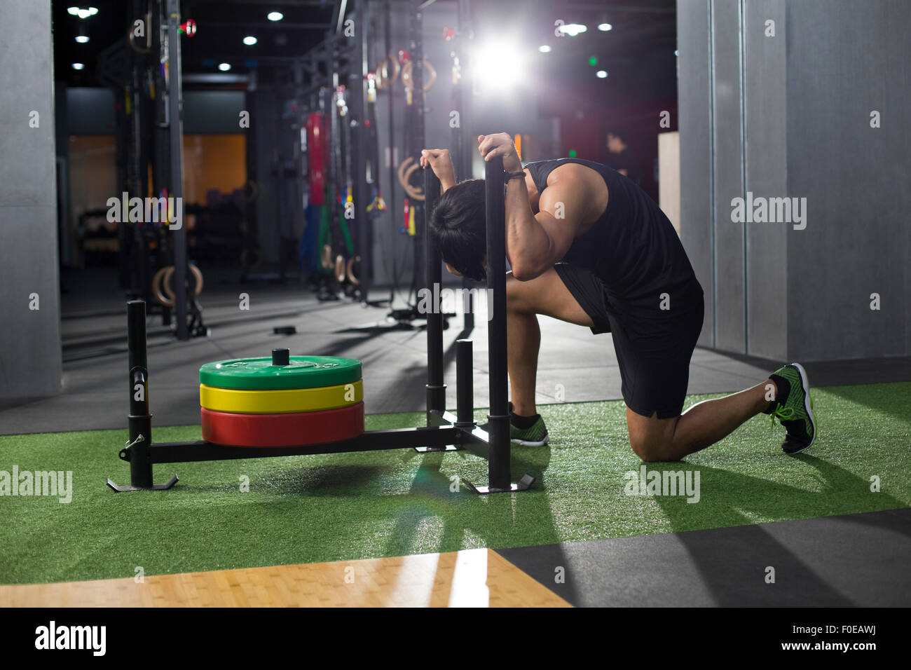 Giovane uomo spingendo la slitta di peso in palestra Foto stock - Alamy