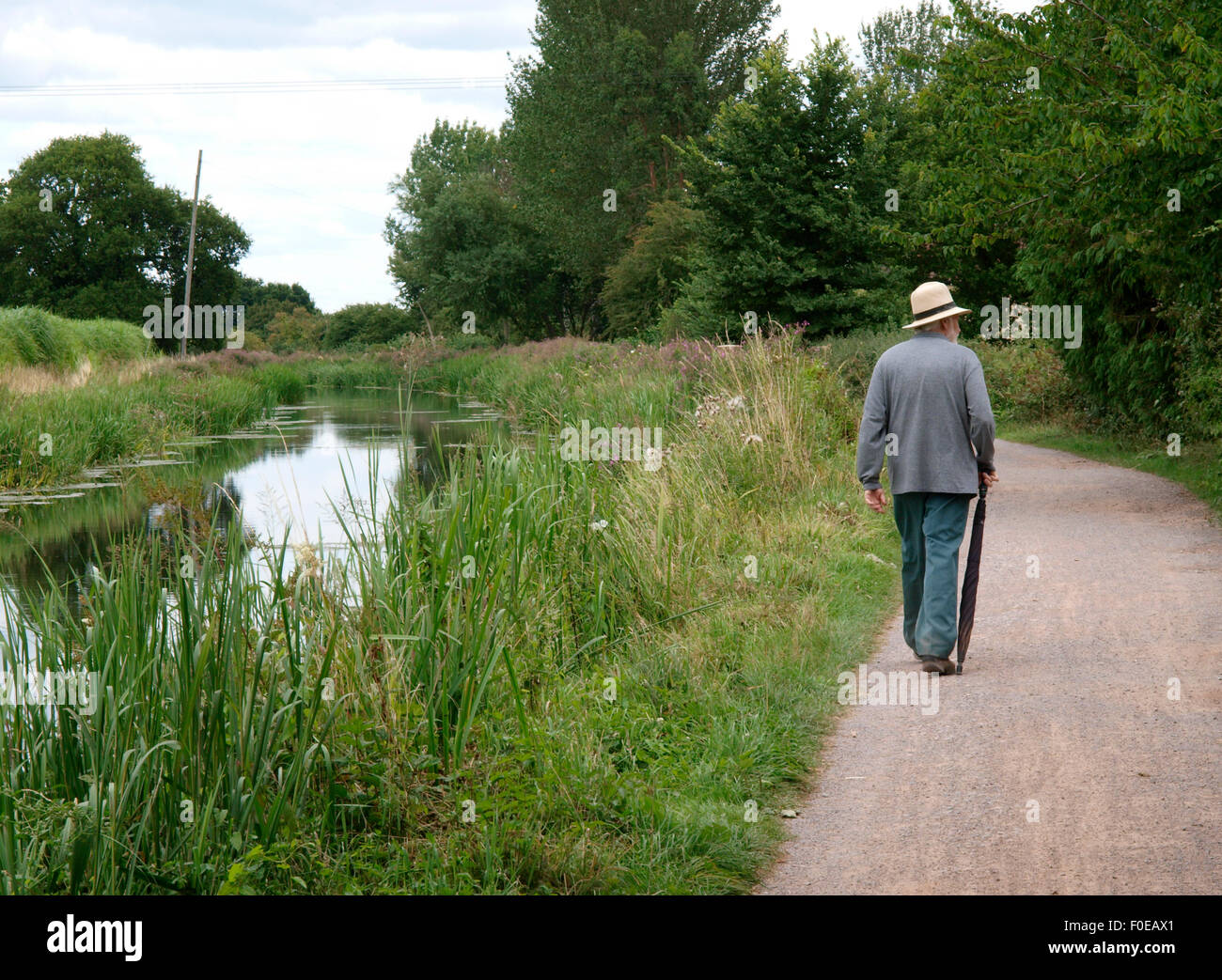 Senior Citizen passeggiando lungo l'alzaia del Bridgwater e Canal a Taunton, Somerset, Regno Unito Foto Stock