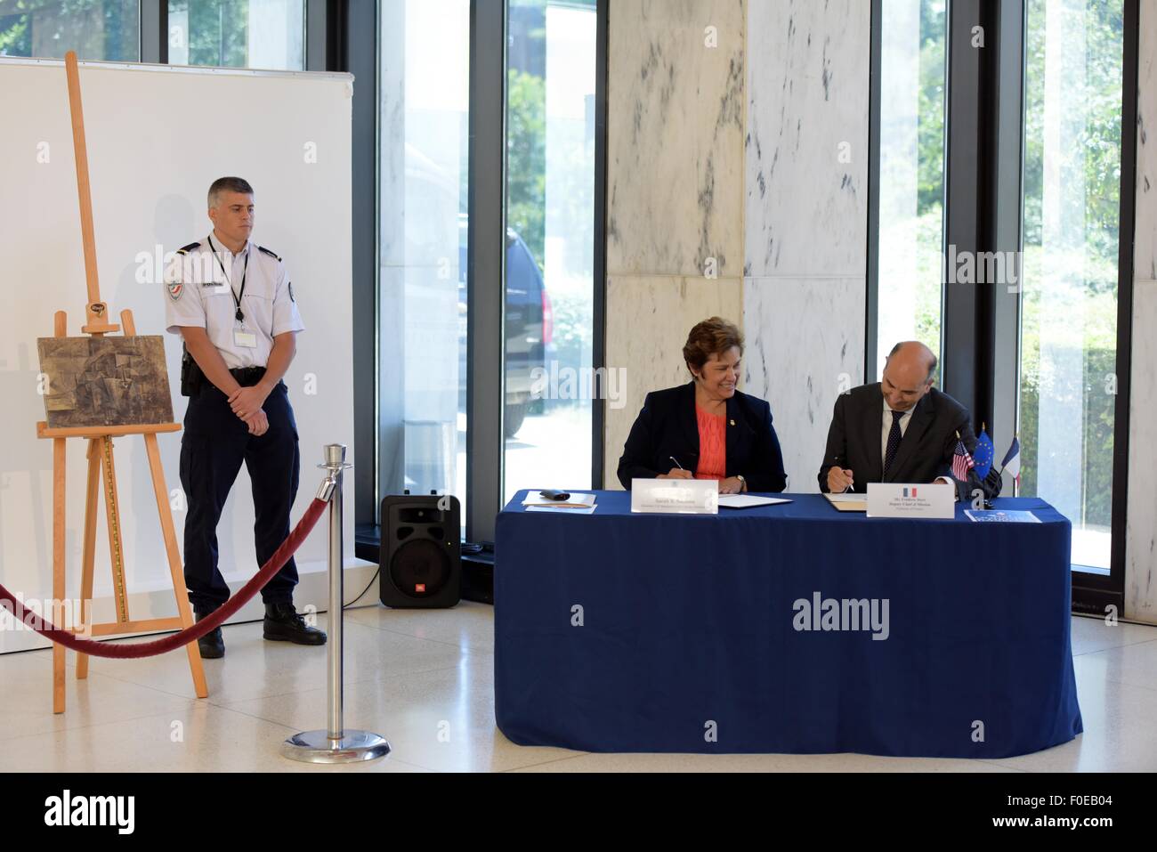 Washington, DC, Stati Uniti d'America. 13 Ago, 2015. Stati Uniti Immigrazione e dogane esecuzione (ghiaccio) Direttore Sarah Saldana (2nd-R) e Frederic Dore, vice capo della missione dell' ambasciata francese, firmare i documenti per il ritorno di Pablo Picasso del dipinto 'La Coiffeusse', presso l' ambasciata di Francia a Washington, DC, Stati Uniti, e il agosto 13, 2015. Negli Stati Uniti il giovedì ha restituito il furto di 15 milioni di dollari la pittura di Picasso 'La Coiffeuse' per Francia, otto mesi dopo che era stato trovato in un pacchetto di FedEx con un prezzo di 37 dollari USA. Credito: Yin Bogu/Xinhua/Alamy Live News Foto Stock