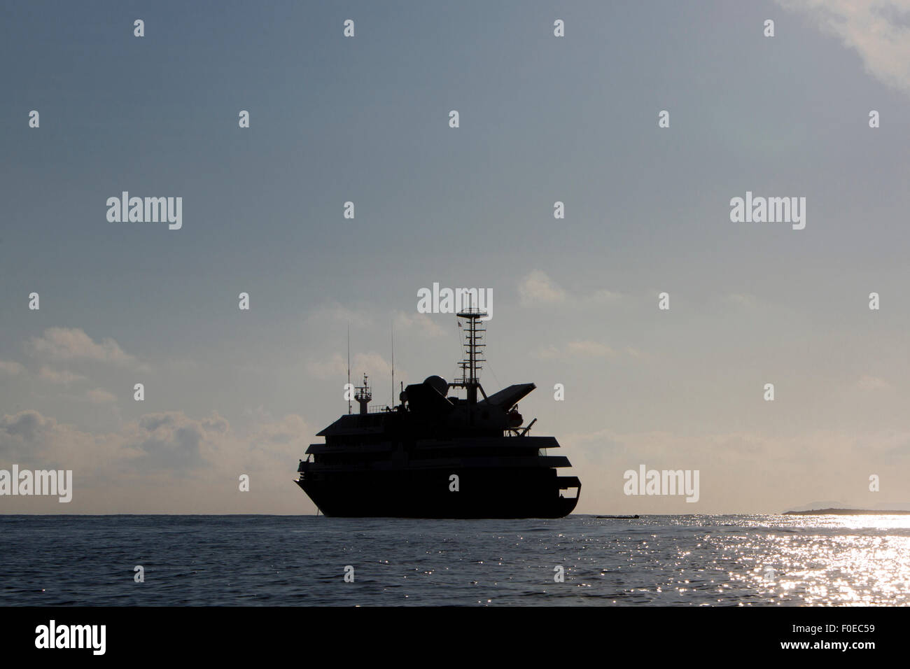 Silhouette di un cruiser di lusso ancorata nella baia di Puerto Ayora con un cielo blu chiaro. Isola Galapagos, Ecuador 2015. Foto Stock