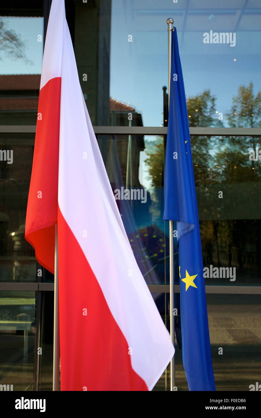 Europei e bandiere polacche flottante in una conferenza europea in Polonia con windows in background Foto Stock