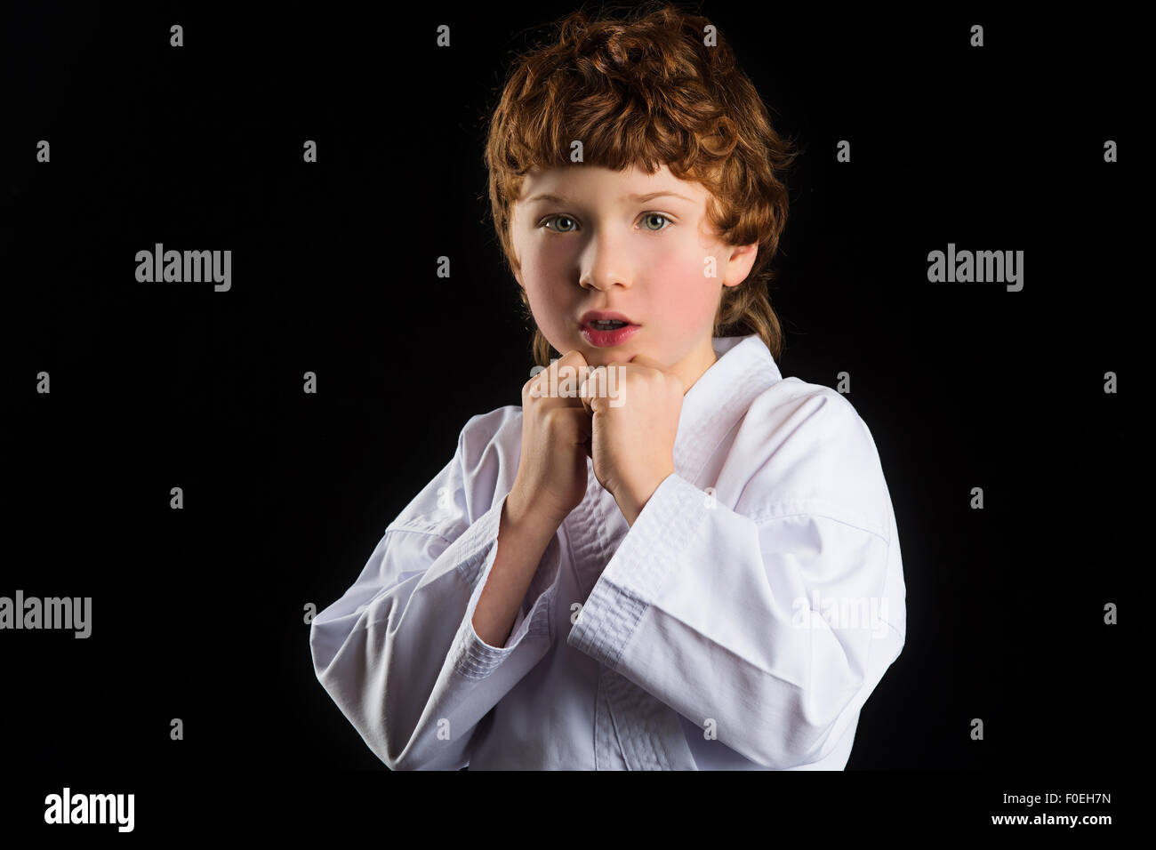 Il Karate boy in kimono bianco isolato su sfondo nero Foto Stock