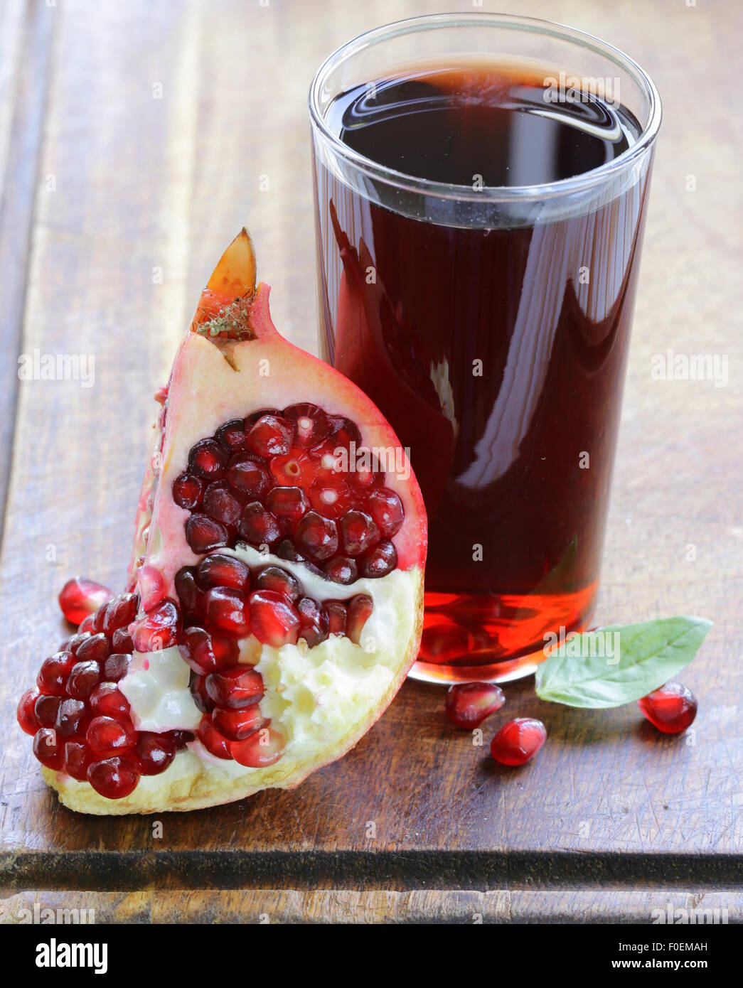 Naturale di succo di melograno su un tavolo di legno Foto Stock