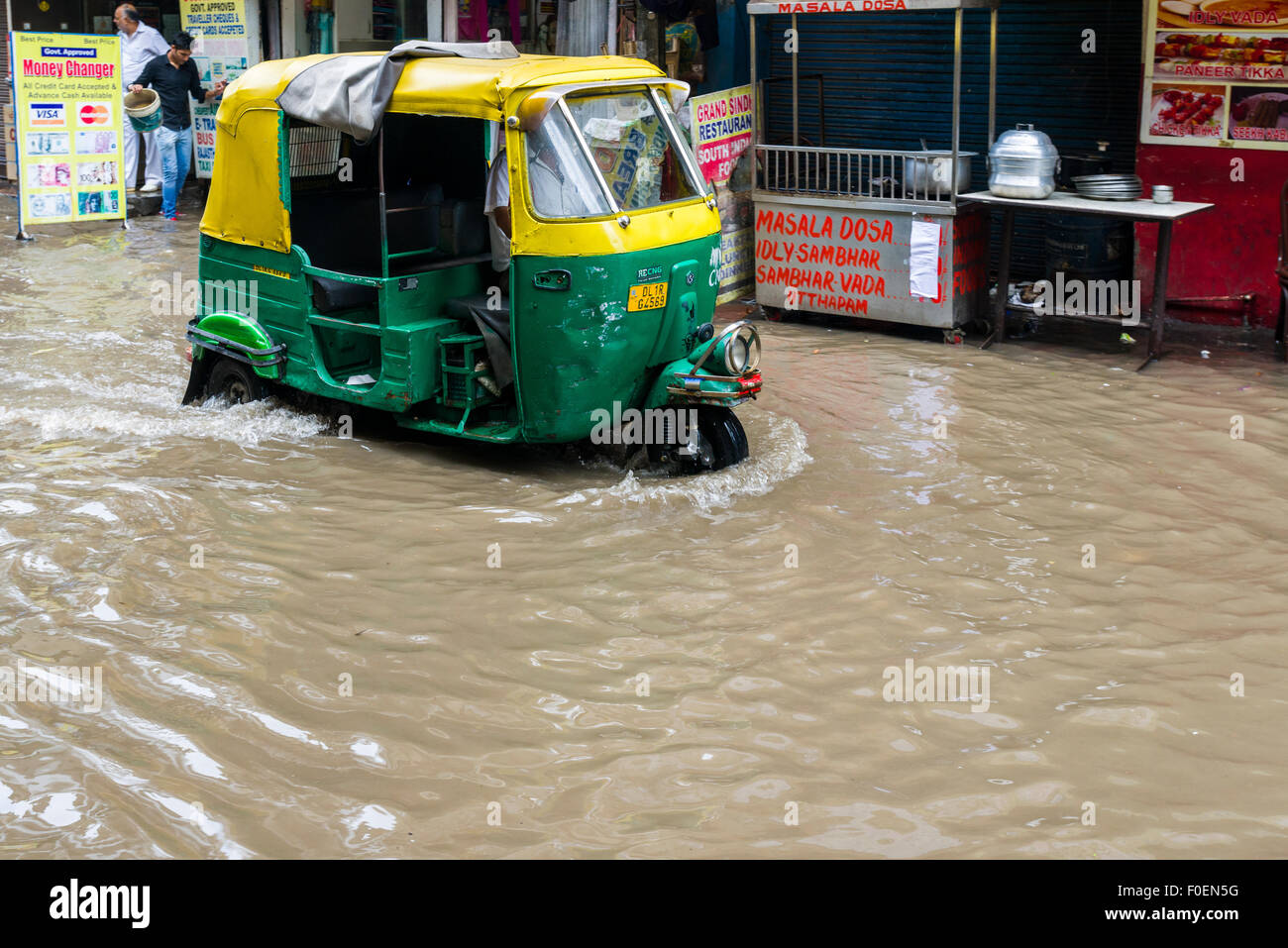 Un motore di risciò si muove attraverso le strade inondate del sobborgo Paharganj dopo un pesanti piogge monsoniche, New Delhi, Delhi Foto Stock