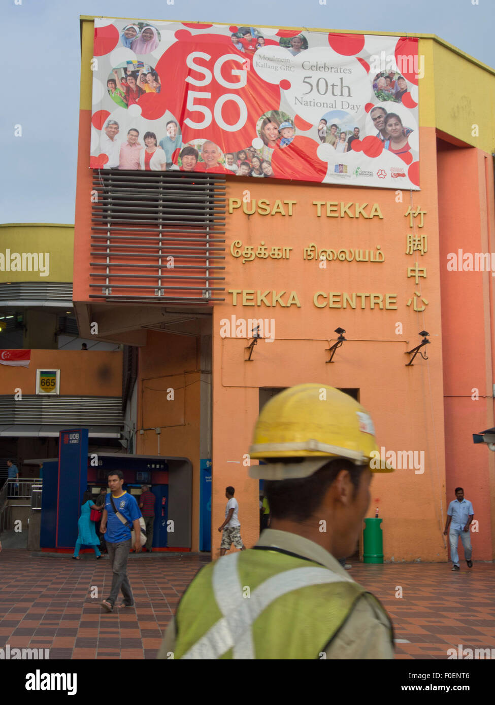 Operaio edile passeggiate oltre i Tekka Centre shopping mall in Little India, Singapore Foto Stock