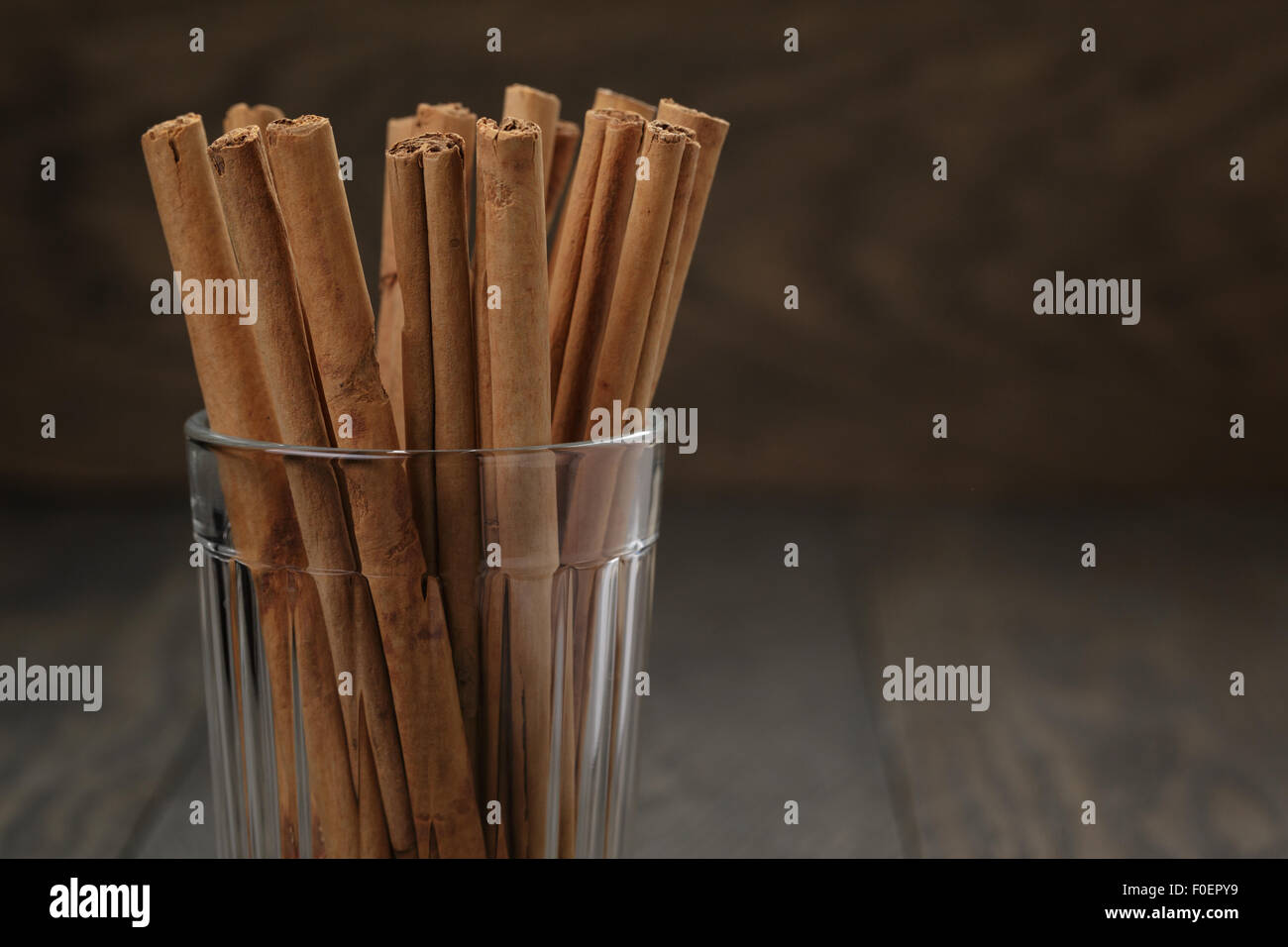 Vero bastoncini di cannella in vetro su un tavolo di legno, selettivo Foto Stock