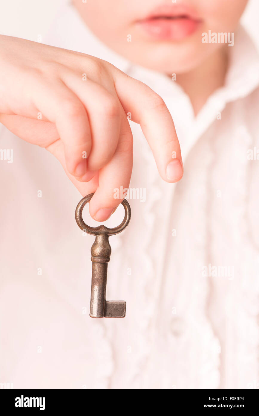 Little Girl holding vintage vecchia chiave in mano Foto Stock