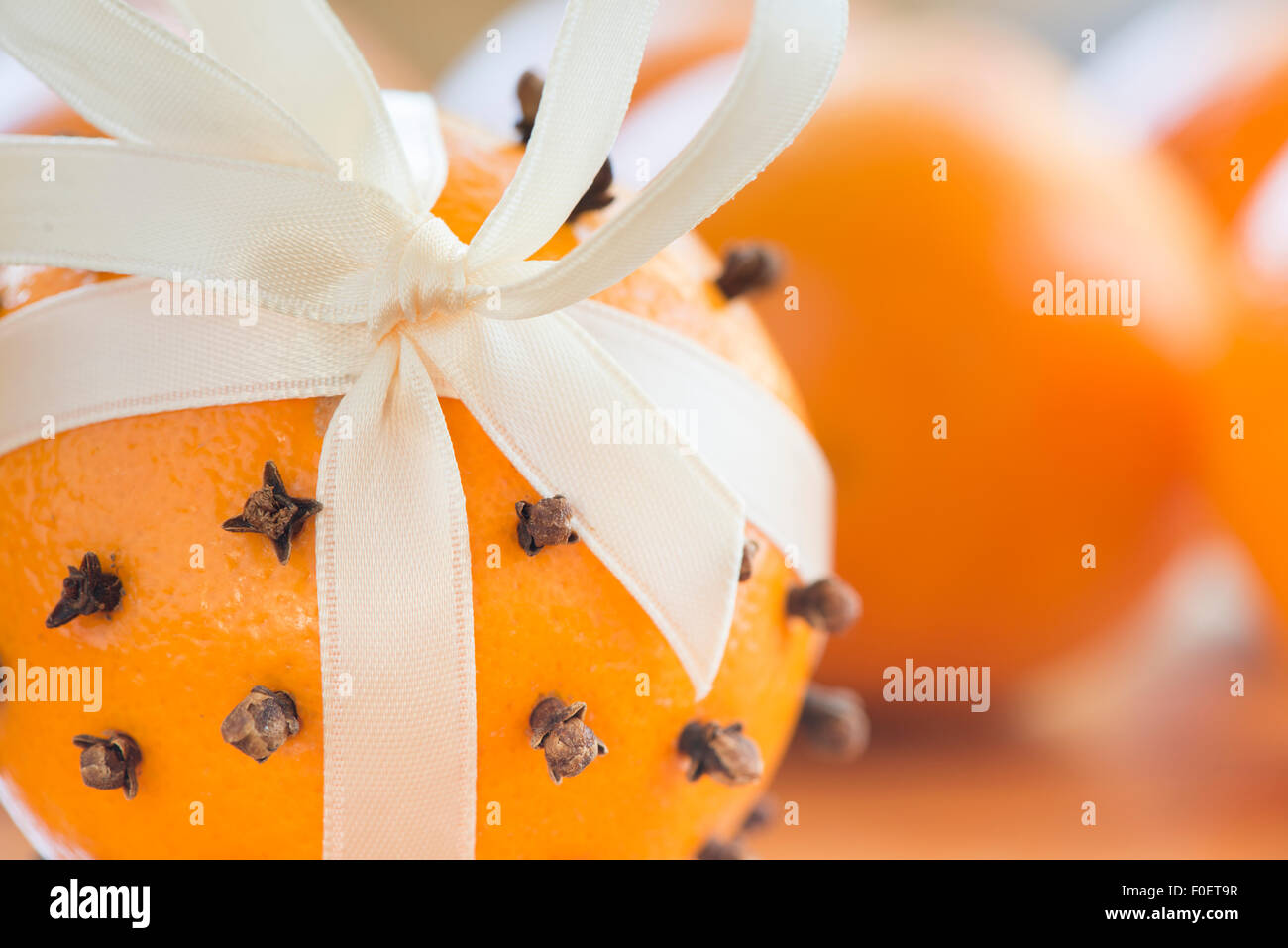 Orange trafitto con chiodi di garofano e decorata con un nastro di seta come parte di un tradizionale decorazione di Natale. Foto Stock