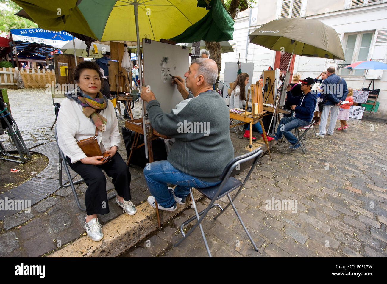 Parigi, Francia - 27 luglio 2015: un pittore è dipinto il ritratto di un turista su Place du Tertre a Montmartre, uno dei più f Foto Stock