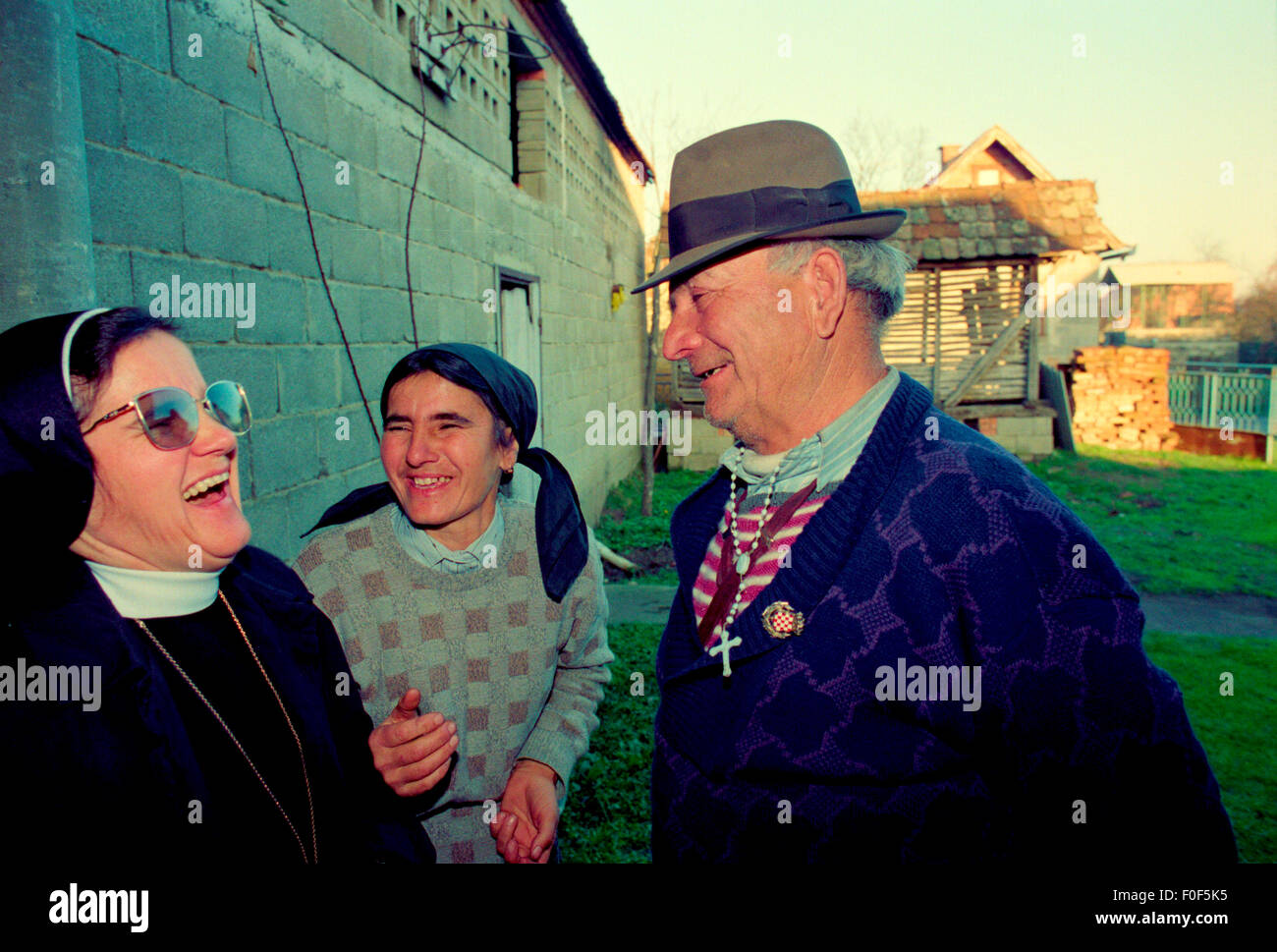 Una suora visita una famiglia portando aiuto in Croazia durante il jugoslavo conflitto bosniaco che sono tra i pochi sopravvissuti in un villaggio distrutto dalla guerra Foto Stock