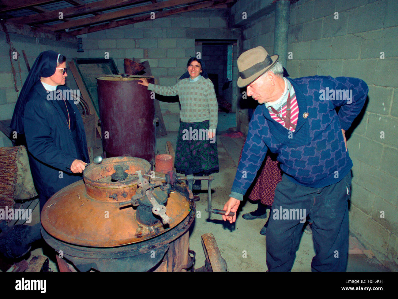 La gente di un villaggio croato mostrano una suora loro Sijivovica Rakia home distilleria durante la guerra in Bosnia Foto Stock