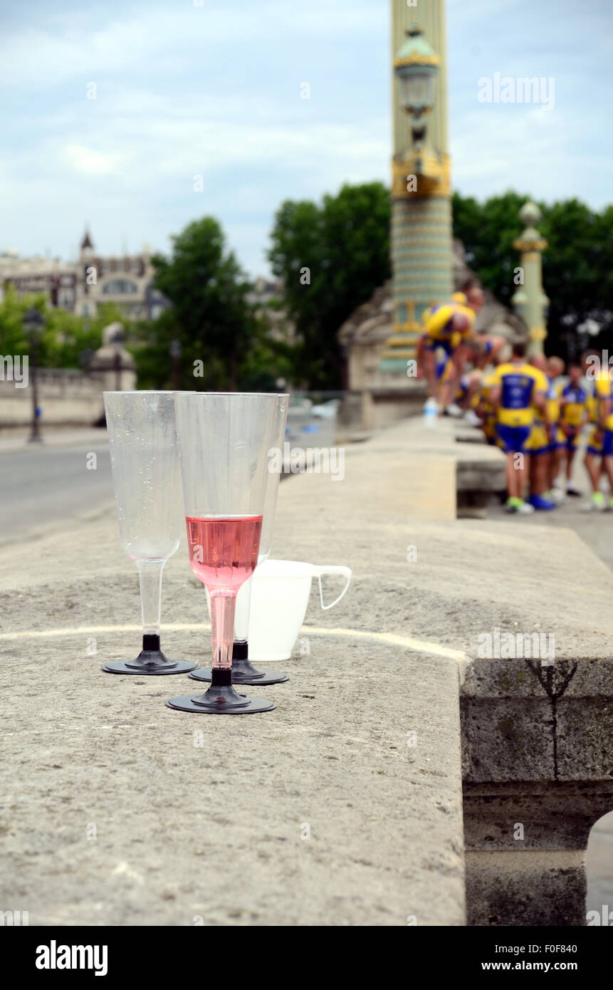 Bicchieri di plastica su un muro a Place de la Concorde mentre una squadra di ciclismo pone per le immagini di sfondo. Foto Stock