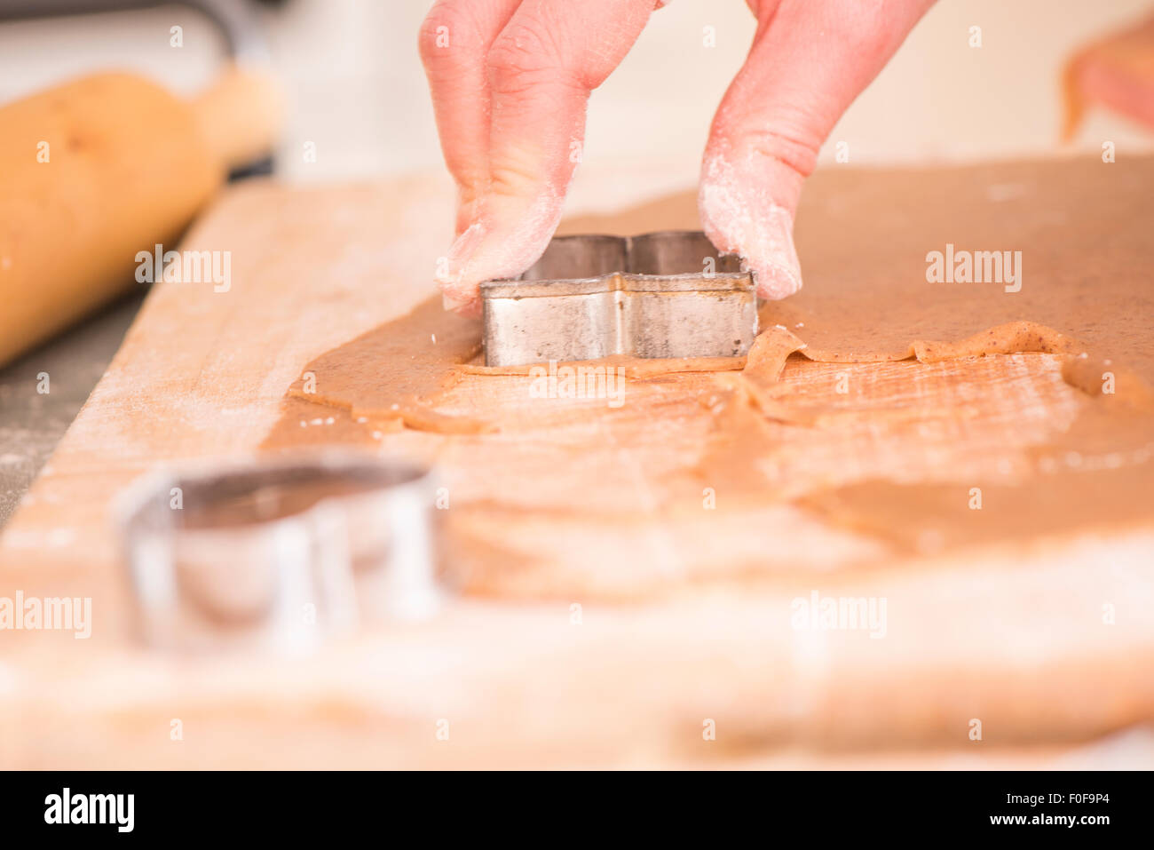 La mano della donna la cottura del pane di zenzero cookies come preparazione di natale. Foto Stock