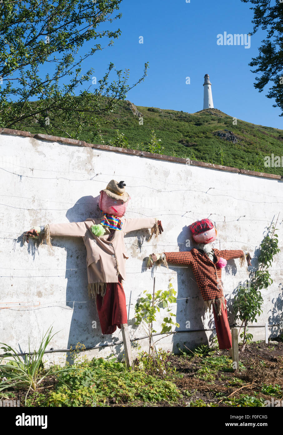 Due scarecrows in Ford il parco giardino con Hoad Hill monumento Ulverston, South Lakeland, Cumbria, England, Regno Unito Foto Stock