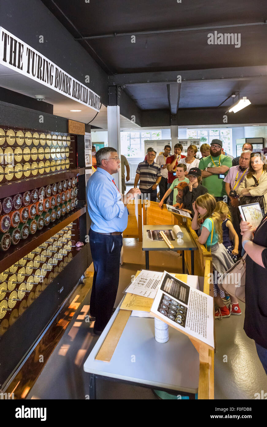 I visitatori ad ascoltare un parlare del ricostruito Turing Bombe codebreaking macchina, Bletchley Park, Buckinghamshire, Inghilterra, Regno Unito Foto Stock