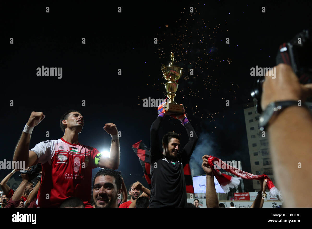 Hebron, West Bank, Territorio palestinese. 14 Ago, 2015. Hebron's Al-Ahly i giocatori di festeggiare dopo una partita di calcio per la Palestina per la finale di coppa con la striscia di Gaza Shejaya del club a Hussein Bin Ali Stadium in Cisgiordania città di Hebron il 14 agosto 2015. Hebron's Al-Ahli ha vinto 2-1 in una drammatica fine per il primo scontro calcistico in quindici anni con un team da israeliano bloccato a Gaza per essere proclamato Campione palestinese. Credito: ZUMA Press, Inc./Alamy Live News Foto Stock