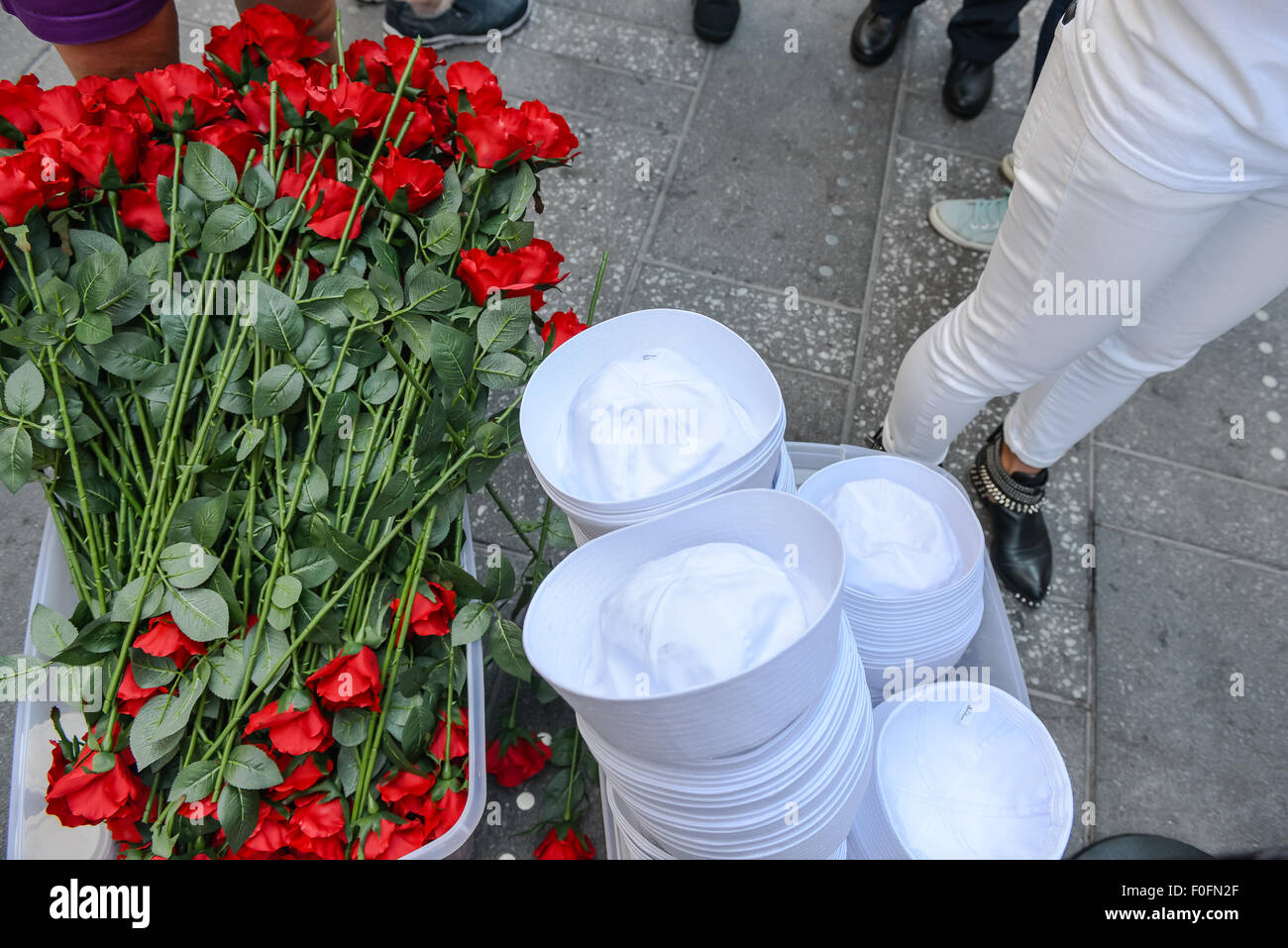 New York, Stati Uniti. 14 Ago, 2015. A gambo lungo rose rosse e marinaio caps attendono la distribuzione ai membri del pubblico che desiderano partecipare al kiss-in. Per contrassegnare il settantesimo anniversario della consegna della giapponese che termina la seconda guerra mondiale, il Times Square Alliance e "acquavite di '45', una seconda guerra mondiale organizzazione legacy, ospitato un kiss-in con membri del pubblico invitato a imitare il marinaio e infermiere in Alfred Eisenstaedt la famosa fotografia. Credito: Albin Lohr-Jones/Pacific Press/Alamy Live News Foto Stock