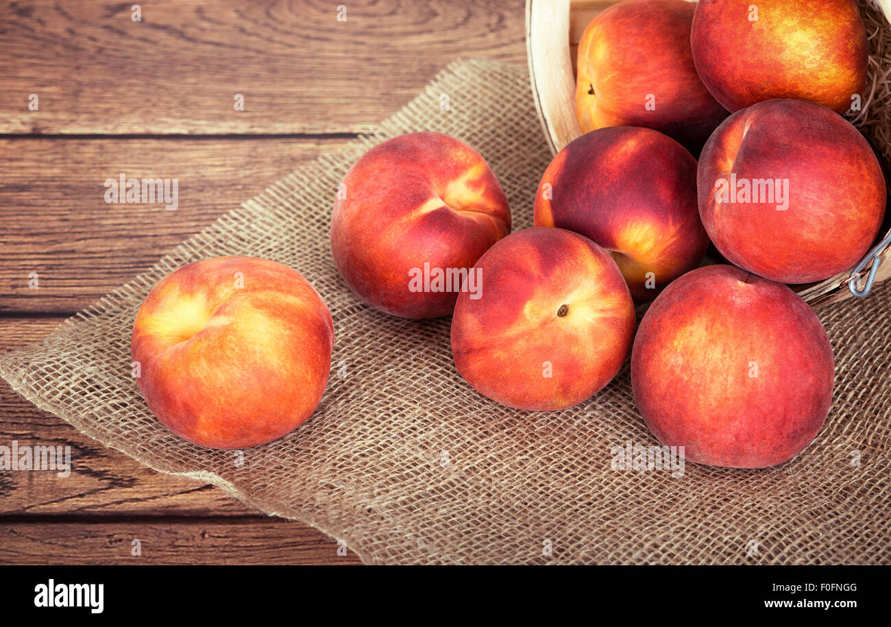 Peschi freschi frutti contro sfondo rustico Foto Stock