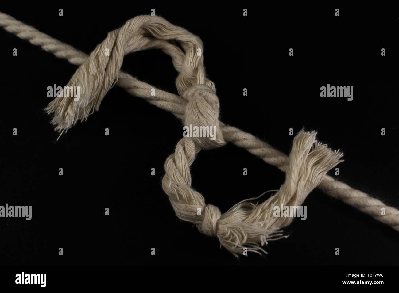 Singolo nodo legatura di due lunghezze di corda insieme con le estremità logorate Foto Stock