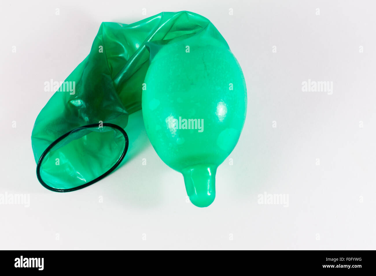 Fecondati singolo uovo di pollo in una verde condom in lattice Foto Stock