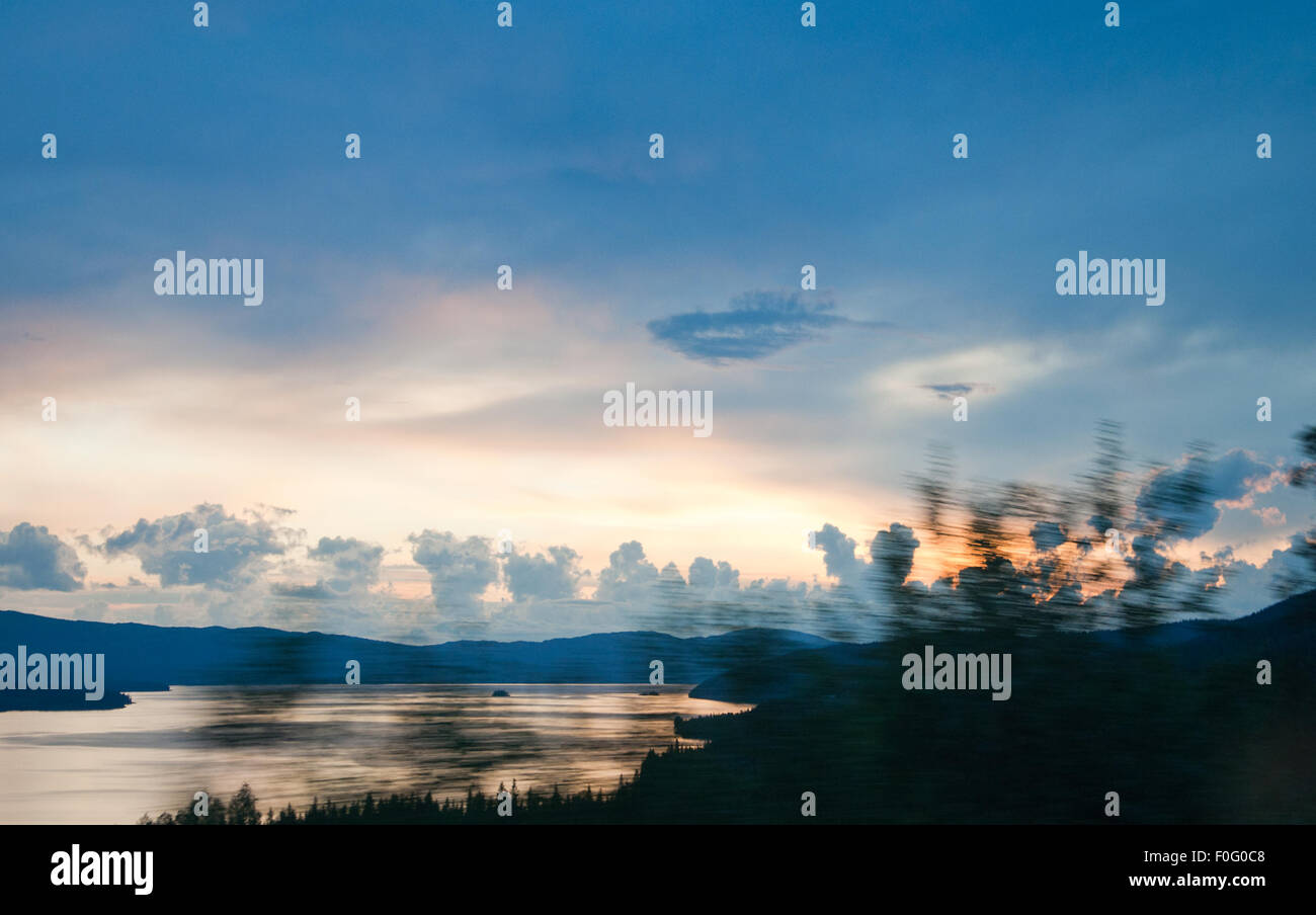 Scenario di mezzanotte con il lago e le nuvole su roadtrip. Paesaggio panoramico in Jamtland, Svezia settentrionale su una luminosa notte d'estate. Foto Stock