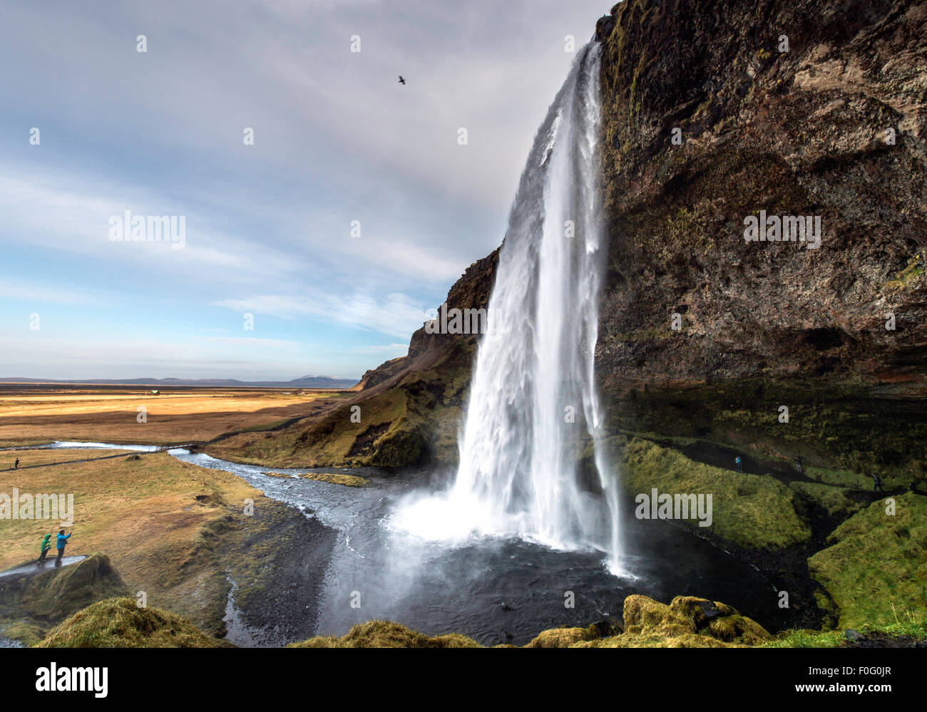 Cascate Seljalandsfoss con i turisti in piedi sulla roccia a sud-ovest dell'Islanda Europa Foto Stock