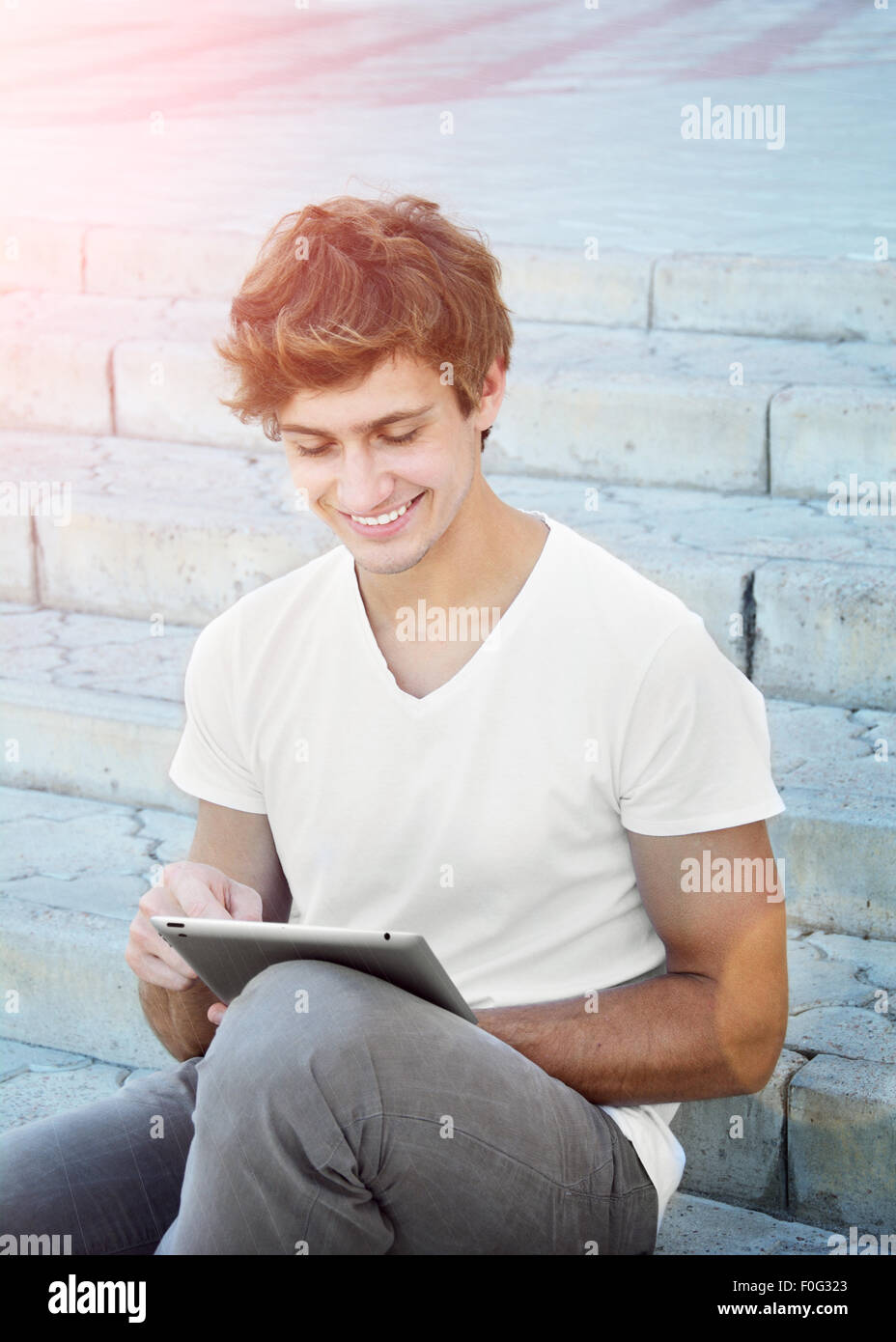 Giovane uomo è utilizzando un tablet all'aperto Foto Stock