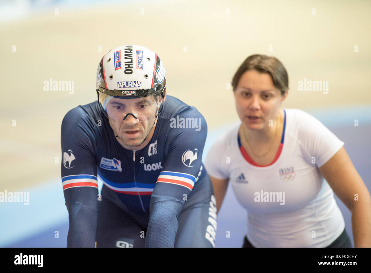 Derby, Regno Unito. Il 15 agosto, 2015. Francois Pervis della Francia è assistito da una squadra femminile helper durante la Rivoluzione serie a Derby Arena, Derby, Regno Unito il 15 agosto 2015. La rivoluzione è una serie professional via racing series con molti dei migliori del mondo via i ciclisti. Questo evento si svolge su 3 giorni dal 14-16 agosto 2015, è un importante evento di preparazione per il Rio 2016 Giochi Olimpici, consentendo britannico piloti di segnare punti qualificanti per i giochi. Credito: Andrew Torba/Alamy Live News Foto Stock