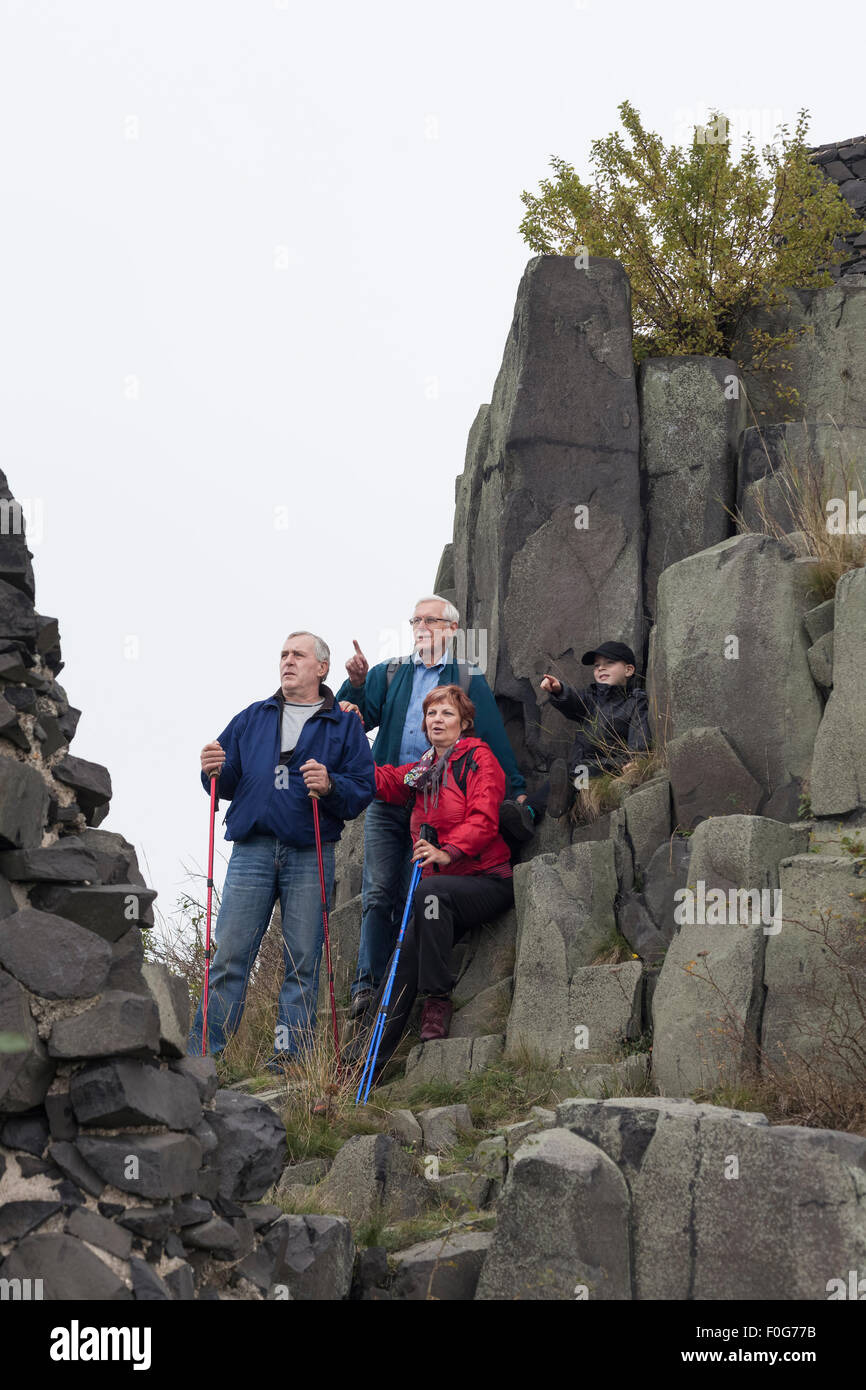 Tre anziani con bambino ragazzo di puntamento e di escursionismo su terreno roccioso. Foto Stock