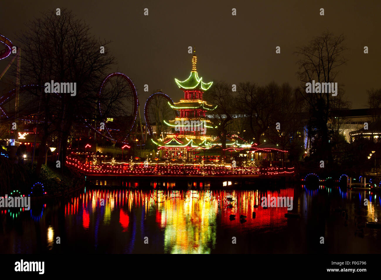 Natale al Tivoli a Copenhagen di notte. Le Luminarie sulla torre del lago in background Foto Stock