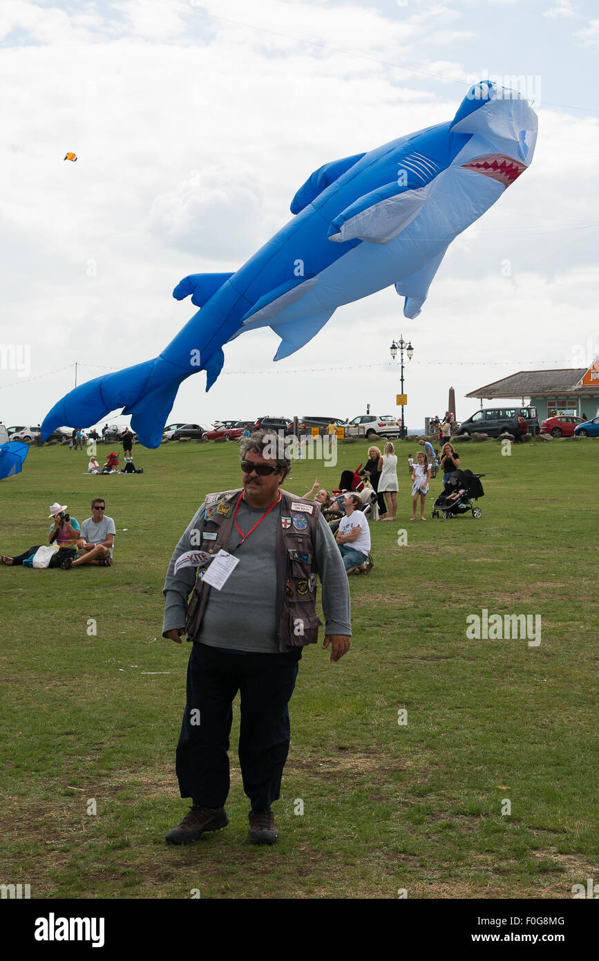 Portsmouth, Regno Unito. Il 15 agosto 2015. Un gestore di kite si allontana dalla grande aquilone di squalo ha appena volato presso l'International Kite Festival. Credito: MeonStock/Alamy Live News Foto Stock