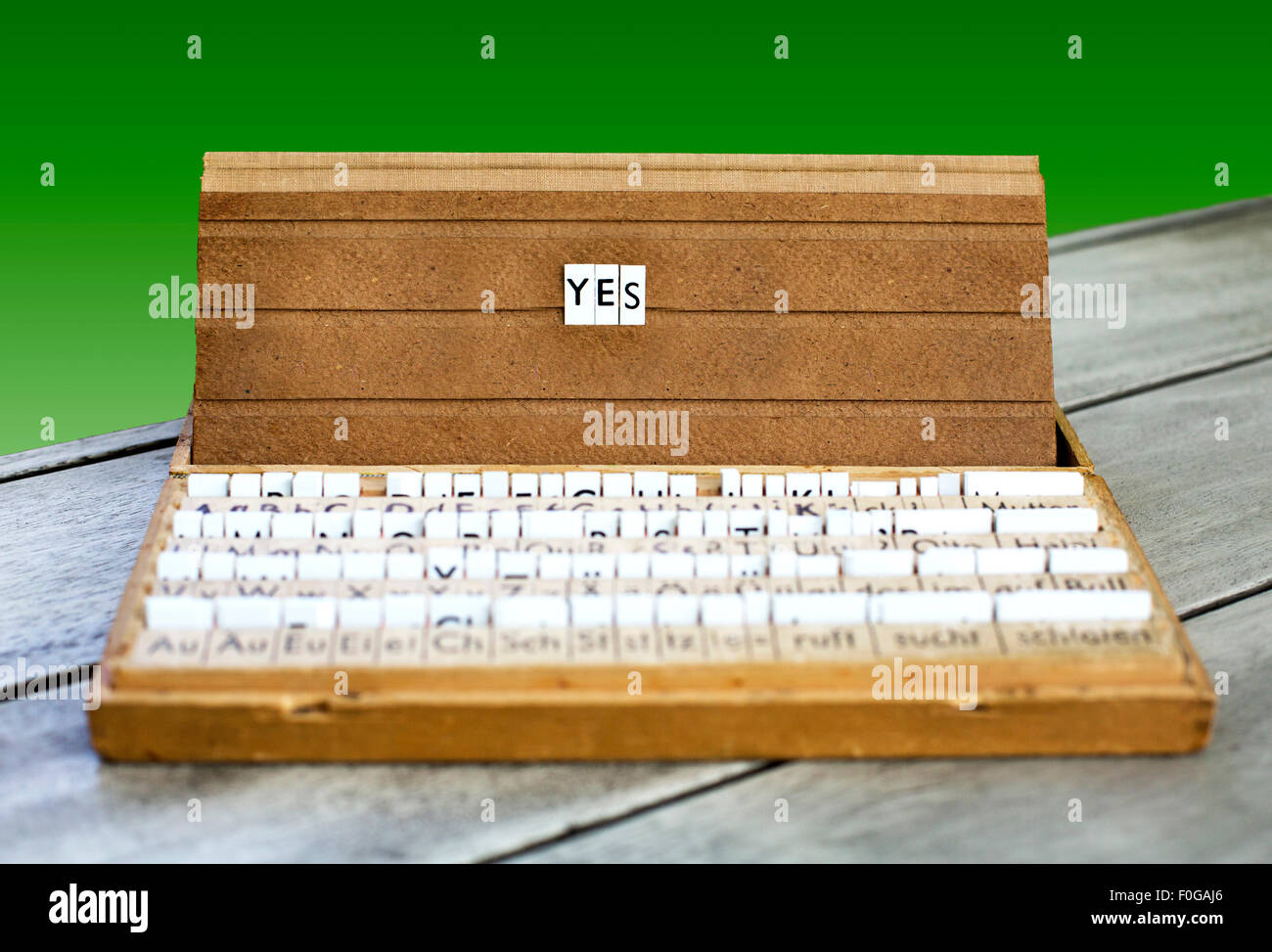 La parola "sì" su una vecchia scuola letter box con uno sfondo verde Foto Stock